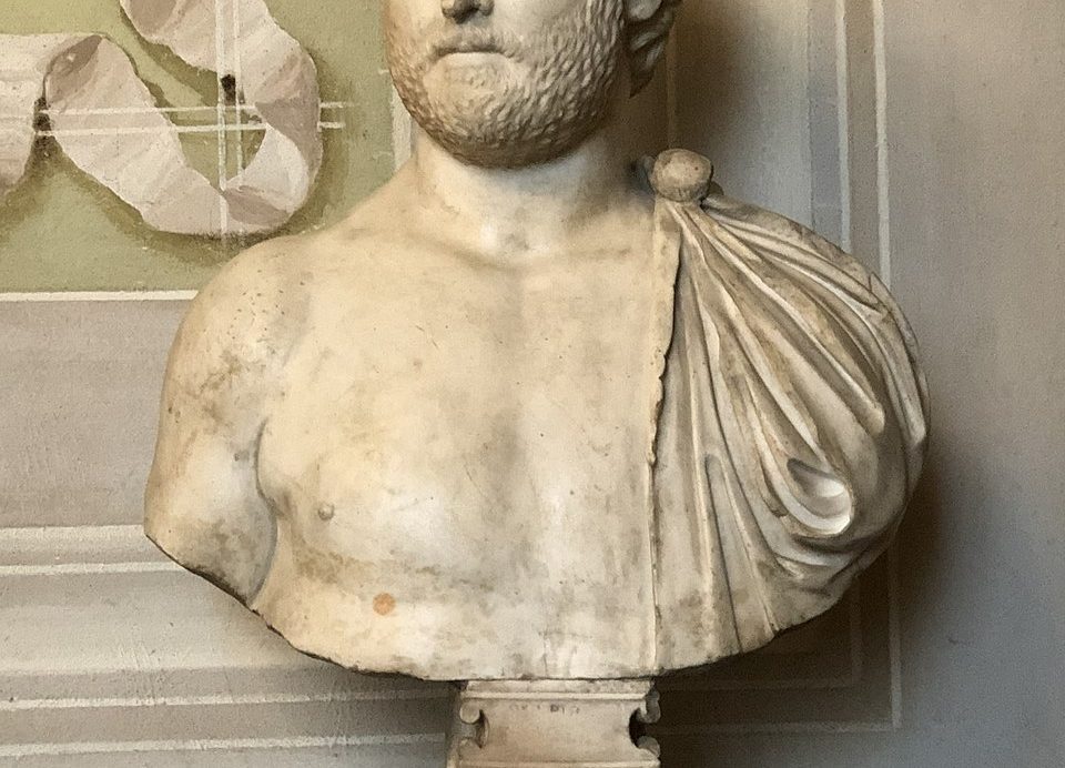 Marble statue of the Roman poet Ovid, depicted seated in thoughtful repose, draped in a toga, symbolizing his exile and reflective nature.