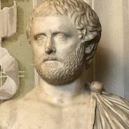 Marble statue of the Roman poet Ovid, depicted seated in thoughtful repose, draped in a toga, symbolizing his exile and reflective nature.