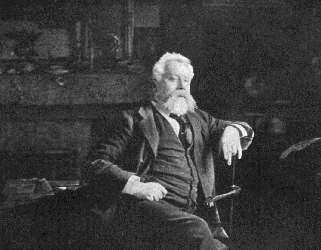 Historical black-and-white photograph labeled William Ernest Henley, showing an older bearded man seated in a chair.