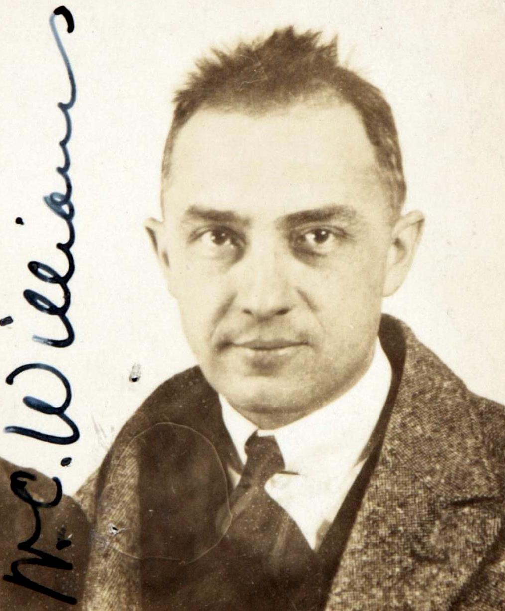 Black-and-white passport photograph of William Carlos Williams in 1921, wearing a suit and tie